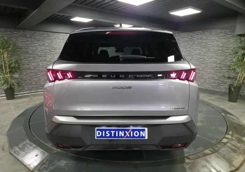 Vue arrière d'un Peugeot 5008 gris métallisé 2025 avec feux arrière LED à 3 griffes et bandeau noir laqué.
