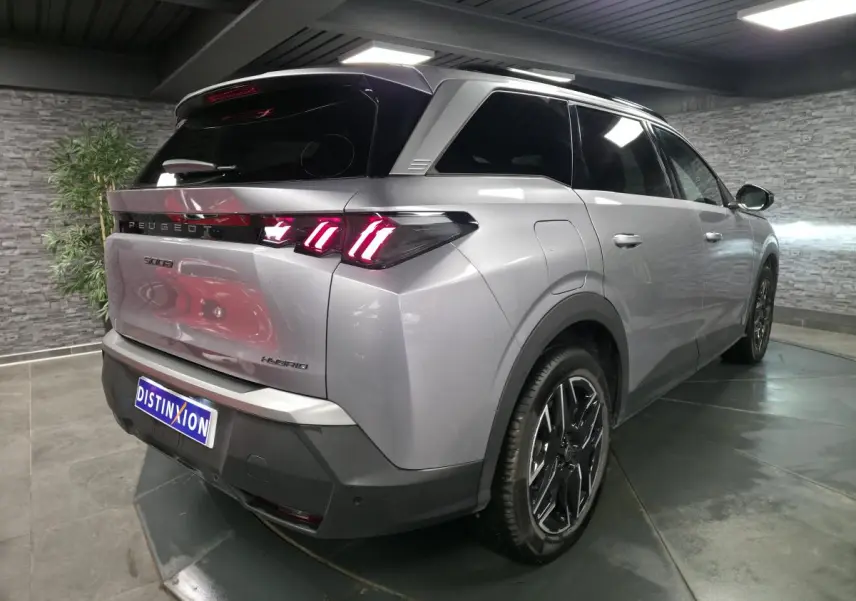 Vue 3/4 arrière droite du Peugeot 5008 gris métallisé avec feux arrière LED à 3 griffes et jantes alliage 19 pouces.