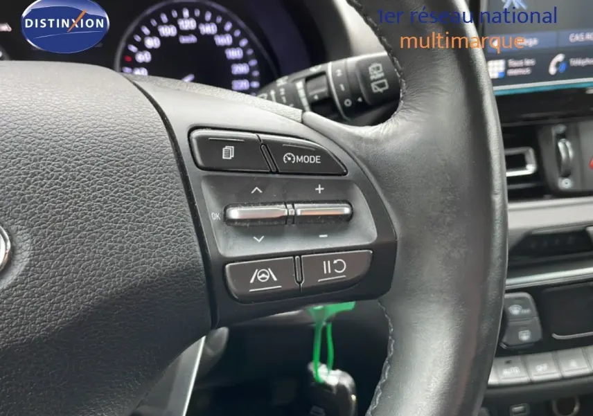 Gros plan sur le volant en cuir noir de la Hyundai i30 SW 2021, avec commandes intégrées et tableau de bord en arrière-plan.