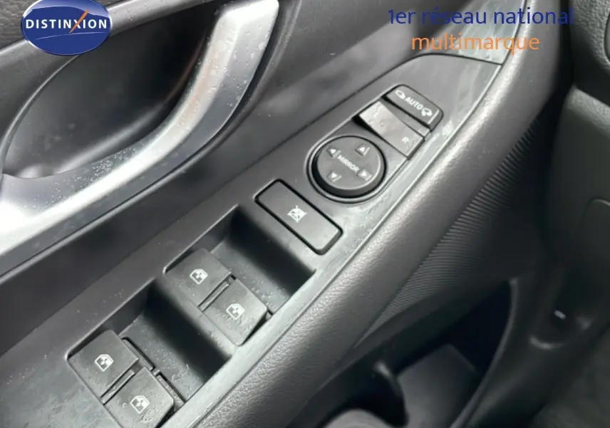 Gros plan sur la commande des vitres électriques côté conducteur d’une Hyundai i30 SW blanc polaire, intérieur noir.