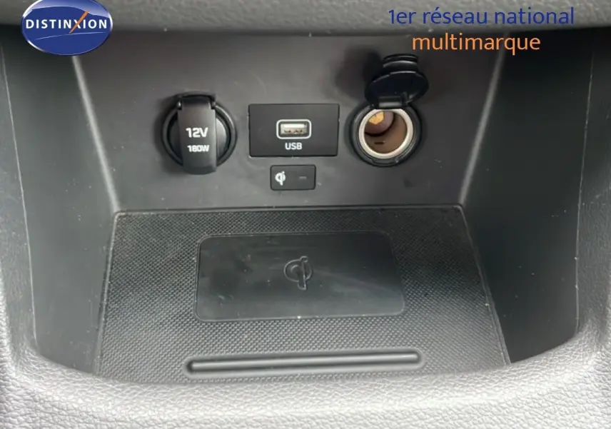 Gros plan sur la console centrale de la Hyundai i30 SW 2021, montrant prises USB, allume-cigare et chargeur sans fil.