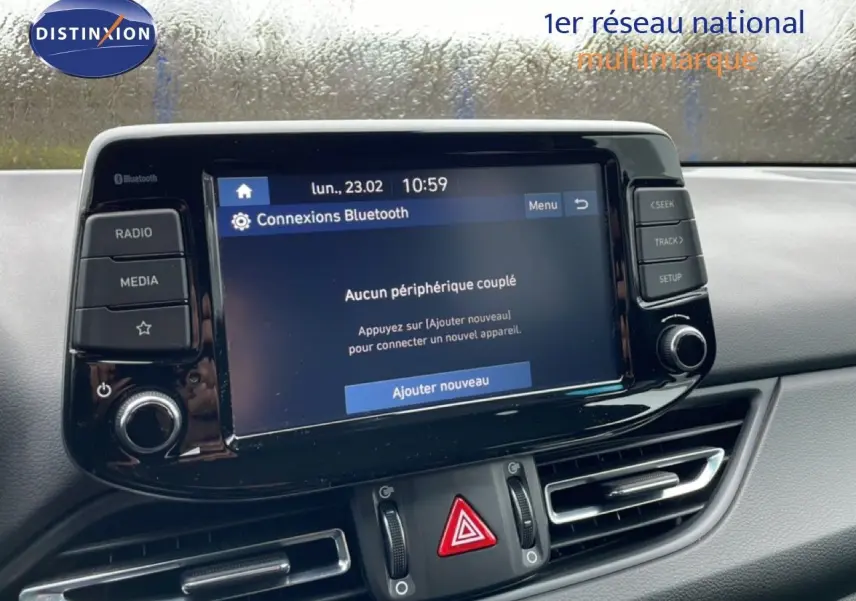 Vue rapprochée de l’écran tactile central et des commandes du tableau de bord d’une Hyundai i30 SW blanc polaire 2021.