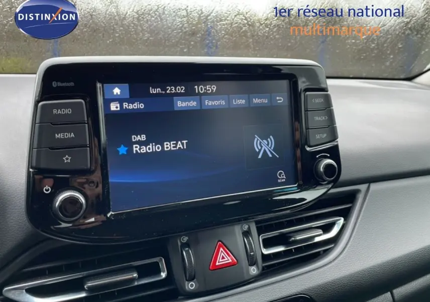 Vue rapprochée de l'écran multimédia central et des commandes de ventilation d'une Hyundai i30 SW blanche polaire de 2021.