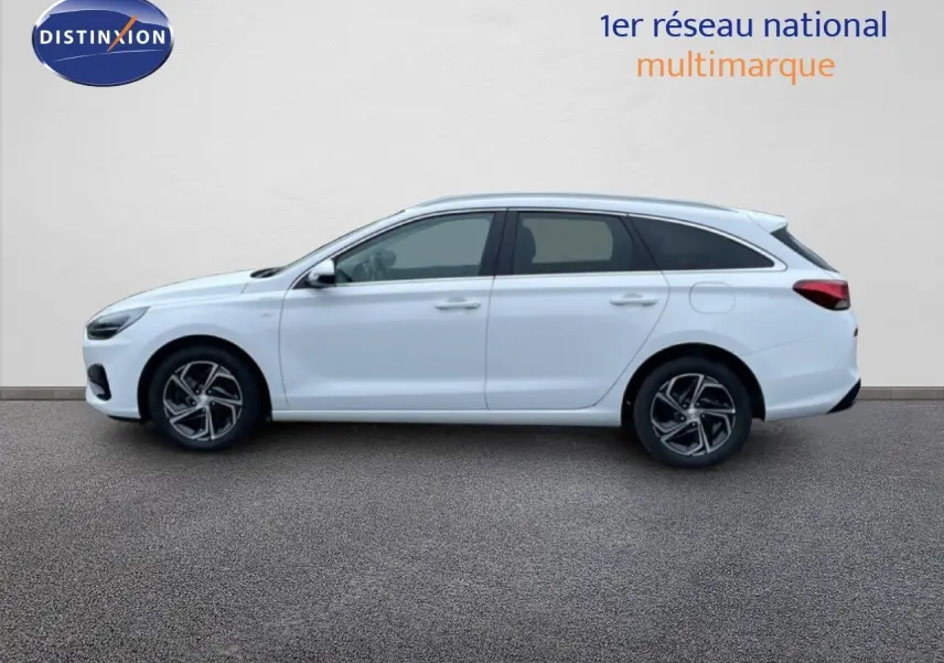 Vue latérale droite d'une Hyundai i30 SW blanche polaire, break compact avec jantes alliage et vitres teintées.