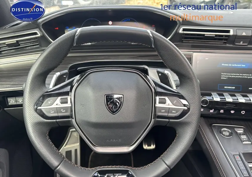 Vue rapprochée du volant cuir multifonction Peugeot 508 SW Hybrid 225 GT avec tableau de bord et écran tactile.