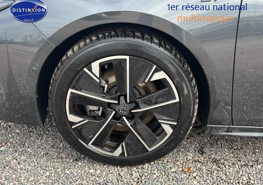 Gros plan sur la jante alu noire et argentée côté avant droit d’une Peugeot 508 SW gris titane 2024.