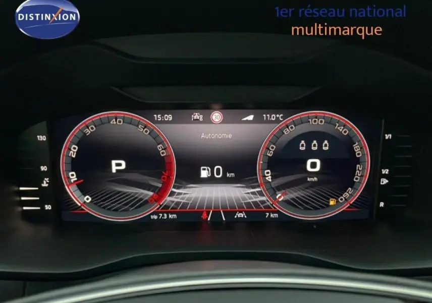 Vue en gros plan du tableau de bord numérique du Skoda Karoq argent, affichant la vitesse et le mode parking.