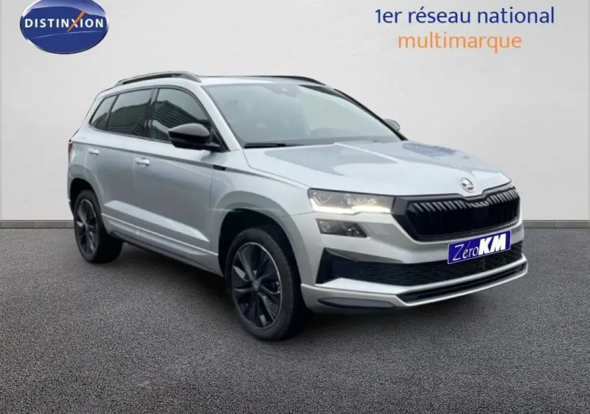 SUV Skoda Karoq argent en 3/4 avant droit avec barres de toit et jantes noires, sur fond neutre.