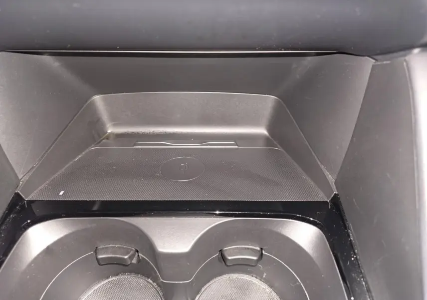 Gros plan sur le chargeur à induction et porte-gobelets noirs dans l'habitacle de la Mazda3 2024.
