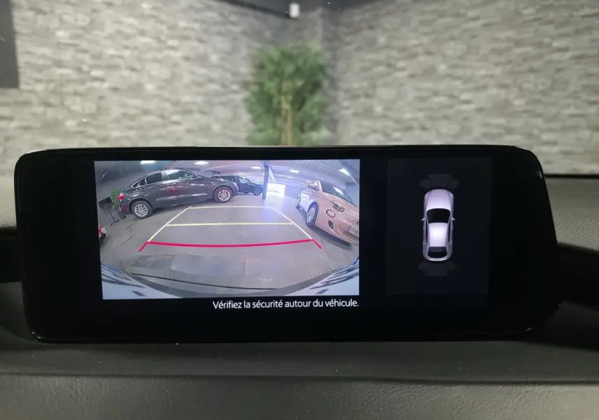 Affichage caméra de recul et capteurs de stationnement du tableau de bord d’une Mazda3 bleu 2024.