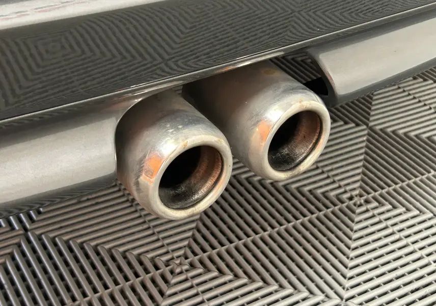 Gros plan sur les deux sorties d’échappement chromées à l’arrière d’une MINI Cooper gris métallisé.