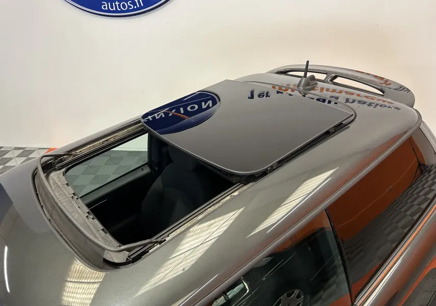 Toit ouvrant panoramique ouvert sur une MINI Cooper gris métallisé vue en plongée depuis l'arrière droit.