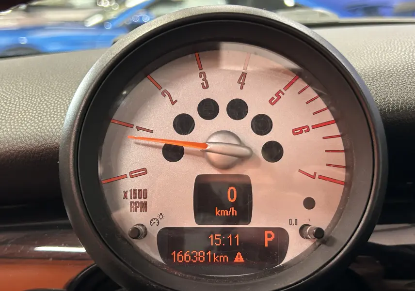 Gros plan sur le compteur central gris de la MINI Cooper Diesel, affichant 0 km/h et 166381 km au tableau de bord.
