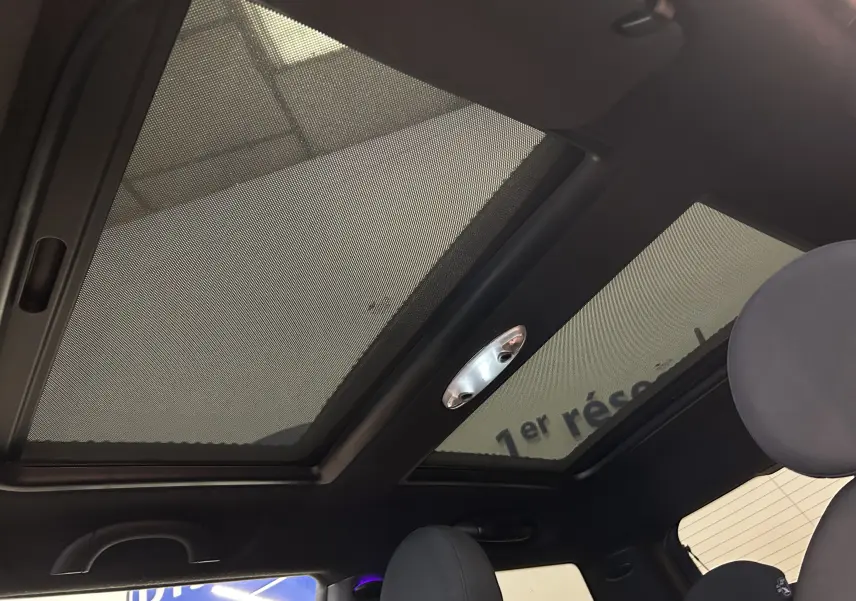 Toit panoramique avec pare-soleil en tissu vu de l'intérieur avant d'une MINI Cooper gris 2011.
