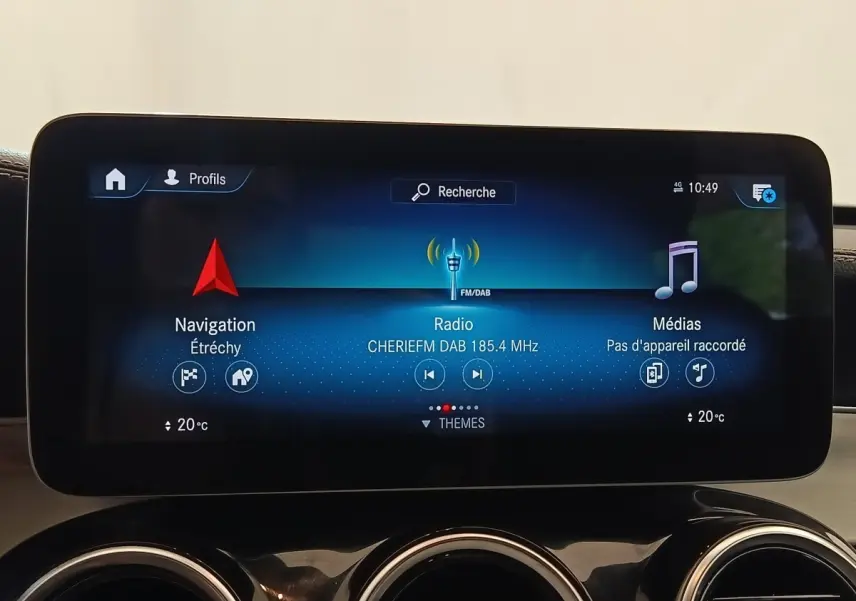 Écran tactile central du Mercedes GLC 300 bleu, affichant navigation, radio DAB et médias, avec aérateurs ronds chromés en dessous.