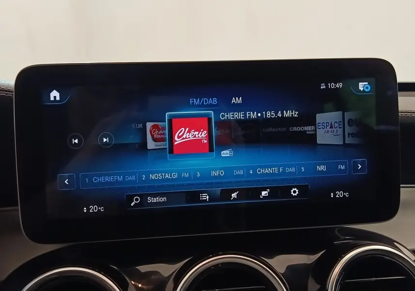 Écran tactile central affichant la radio FM dans l’habitacle d’un Mercedes GLC bleu, vue de face rapprochée.