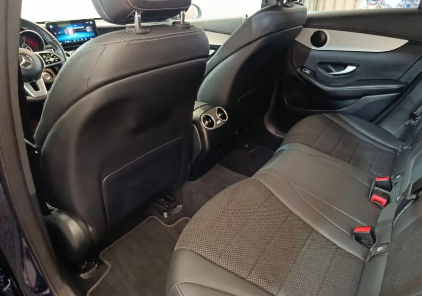 Vue intérieure arrière côté droit du Mercedes GLC 300 DE Business Line 2022, sièges noirs en cuir et tissu, aérateurs centraux visibles.