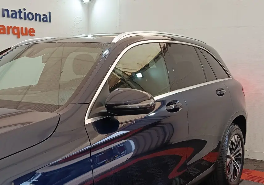 Vue latérale gauche d’un Mercedes GLC 300 DE Business Line 4MATIC bleu avec rétroviseur et jante visibles.