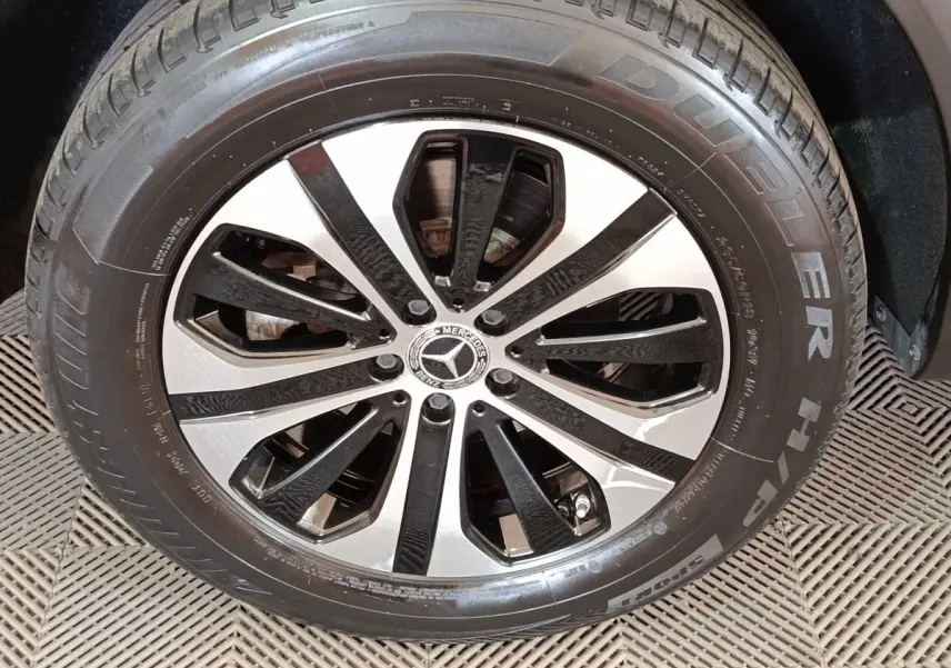 Gros plan sur la jante alliage bicolore noire et argent avec logo Mercedes au centre, pneu Bridgestone visible.