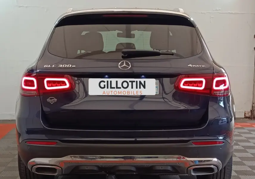 Vue arrière d’un Mercedes GLC 300 DE 4MATIC bleu avec feux LED allumés et double sortie d’échappement chromée.