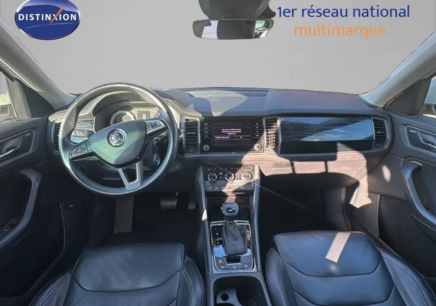 Intérieur du Skoda Kodiaq blanc 2018, vue frontale du poste de conduite avec volant cuir noir et console centrale.