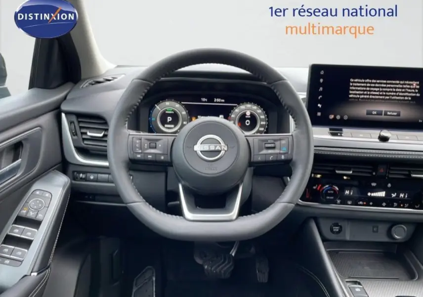 Vue intérieure centrée sur le volant cuir du Nissan Qashqai gris avec cockpit numérique et écran tactile.