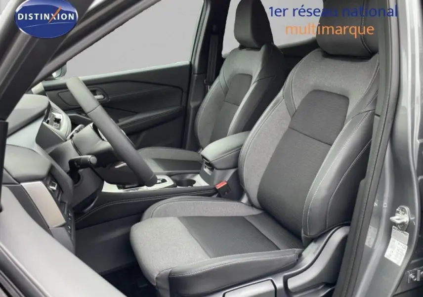 Vue intérieure côté conducteur du Nissan Qashqai gris 2025, sièges bi-matière et volant multifonctions en cuir.