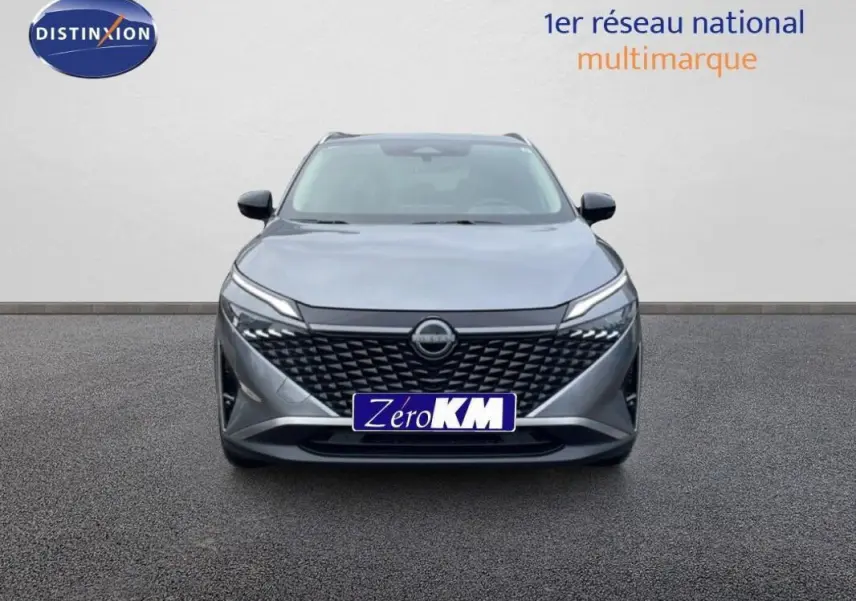 Vue avant d'un Nissan Qashqai gris 2025 avec calandre noire et feux LED fins allumés.