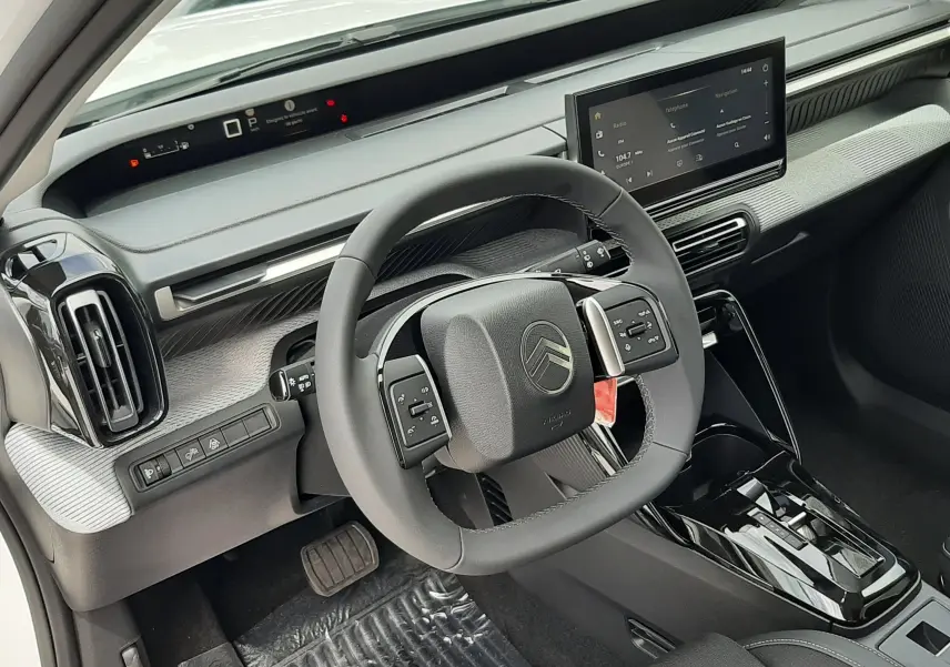 Vue intérieure du poste de conduite de la Citroën C3 Aircross blanc banquise, volant multifonctions et écran tactile central.