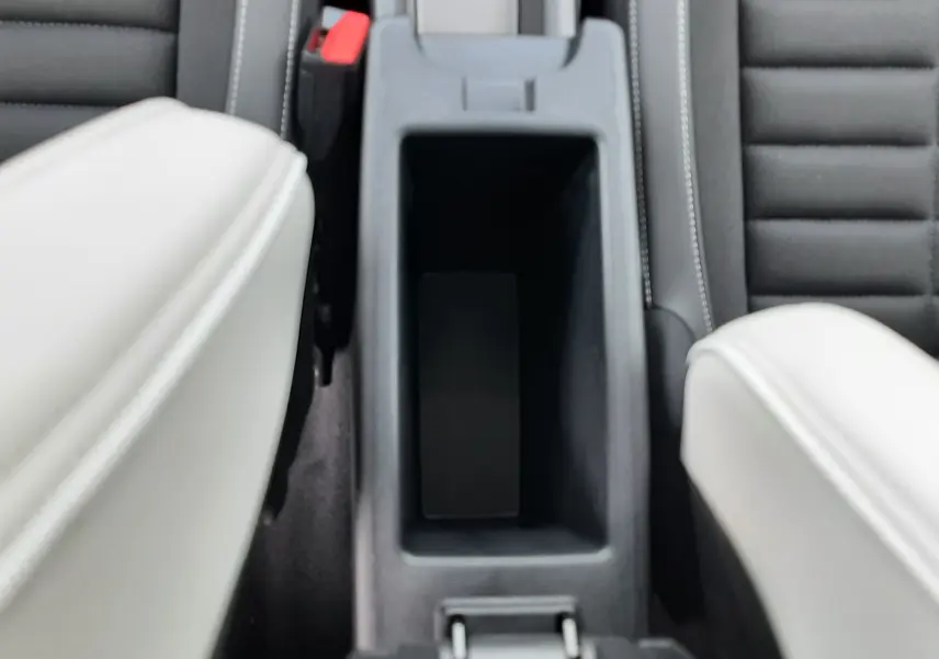 Vue plongeante sur la console centrale noire entre les sièges avant gris clair et tissu noir côtelé du Citroën C3 Aircross 2026.