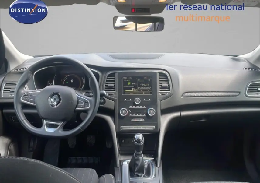 Vue intérieure avant de la Renault Mégane gris titanium, tableau de bord avec écran central et levier de vitesses manuel.