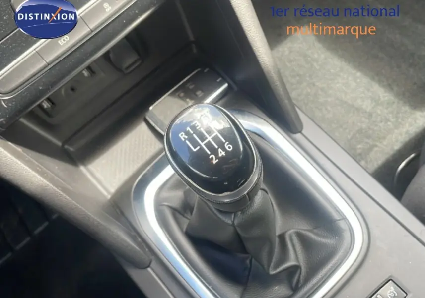 Gros plan sur le levier de vitesses manuel noir de la Renault Mégane gris titanium, avec console centrale environnante.