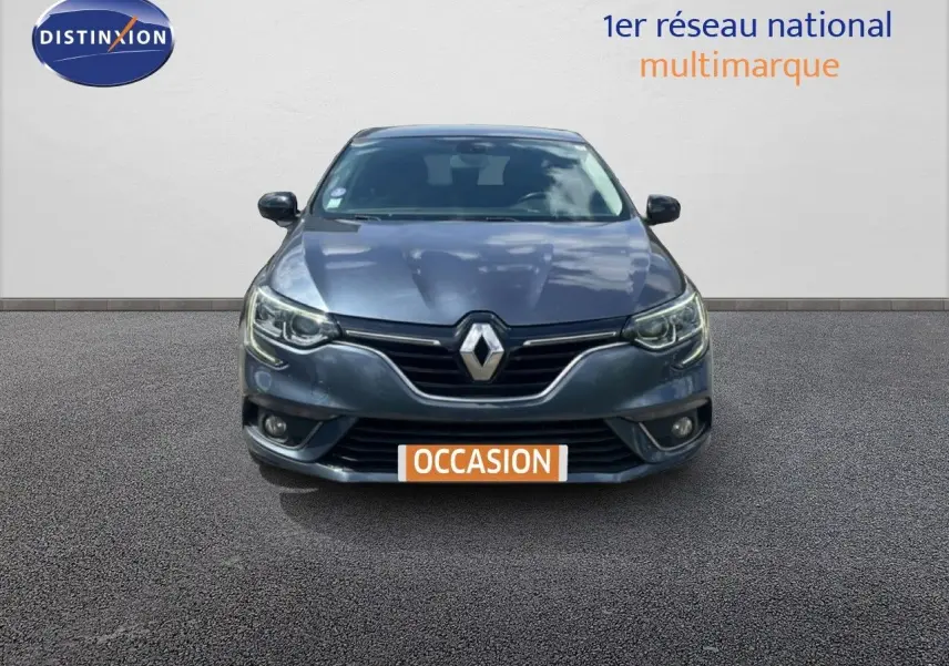 Vue frontale d'une Renault Mégane gris titanium métal avec calandre noire et phares LED allumés.