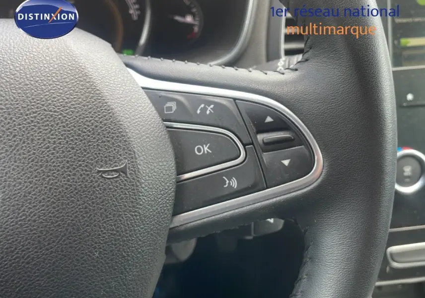 Gros plan sur le volant noir multifonction de la Renault Mégane 1.3 TCE 115CH, avec commandes intégrées visibles.