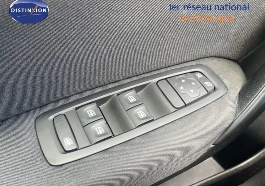 Gros plan sur les commandes des vitres électriques et rétroviseurs sur la porte côté gauche d’une Renault Mégane gris titanium.