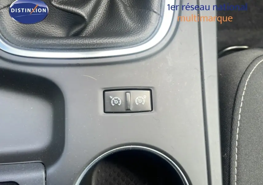 Gros plan sur la console centrale de la Renault Mégane gris titanium, montrant le levier de vitesses manuel et les commandes de régulateur.