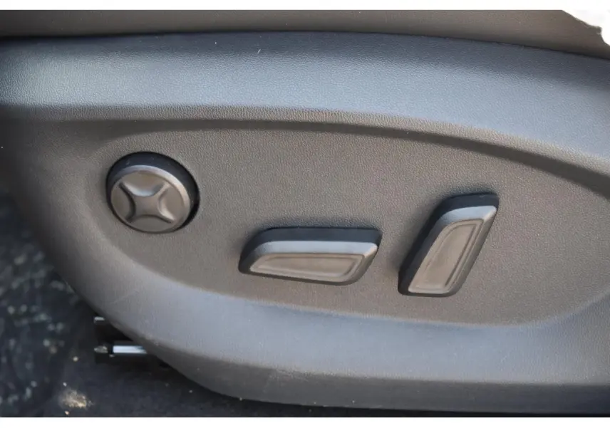 Gros plan sur les commandes de réglage électrique du siège conducteur du MG MOTOR EHS 1.5 Hybrid+ noir, version 2026.