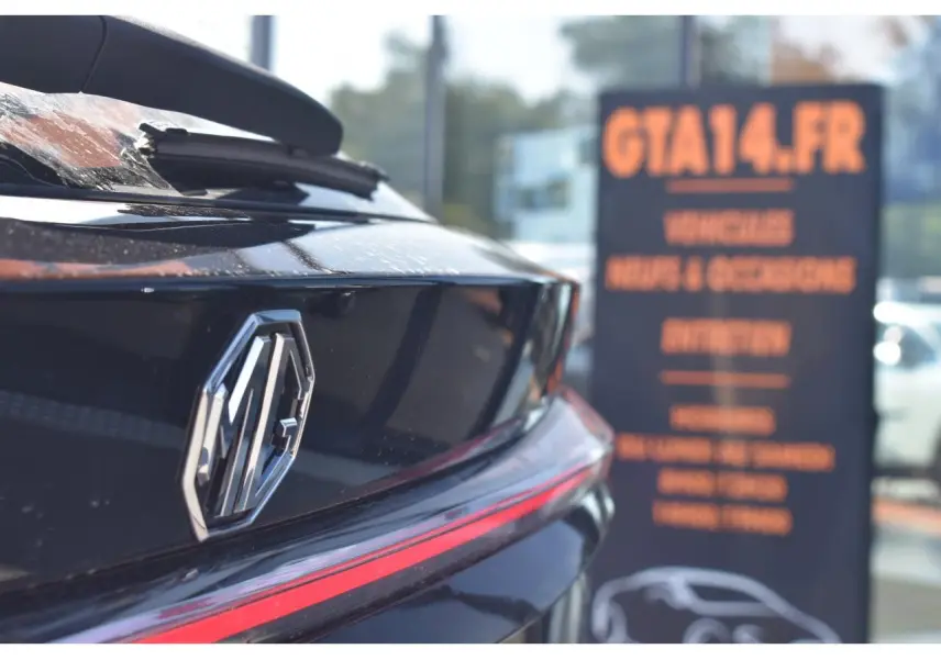 Gros plan sur l'arrière noir brillant du MG EHS 1.5 Hybrid+ avec logo MG et bande lumineuse rouge intégrée.