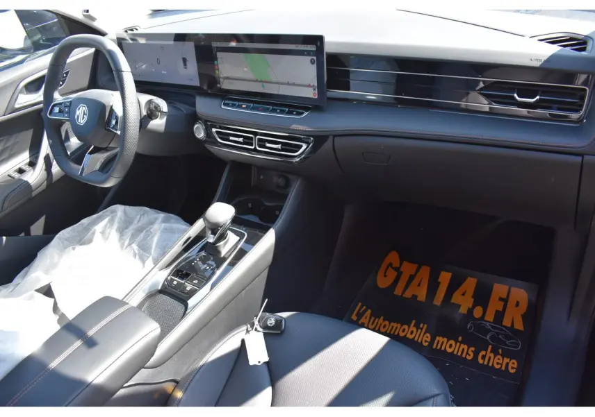 Intérieur du MG Motor EHS 1.5 Hybrid+ 224 ch Luxury 2026, vue côté passager montrant tableau de bord et console centrale noire.