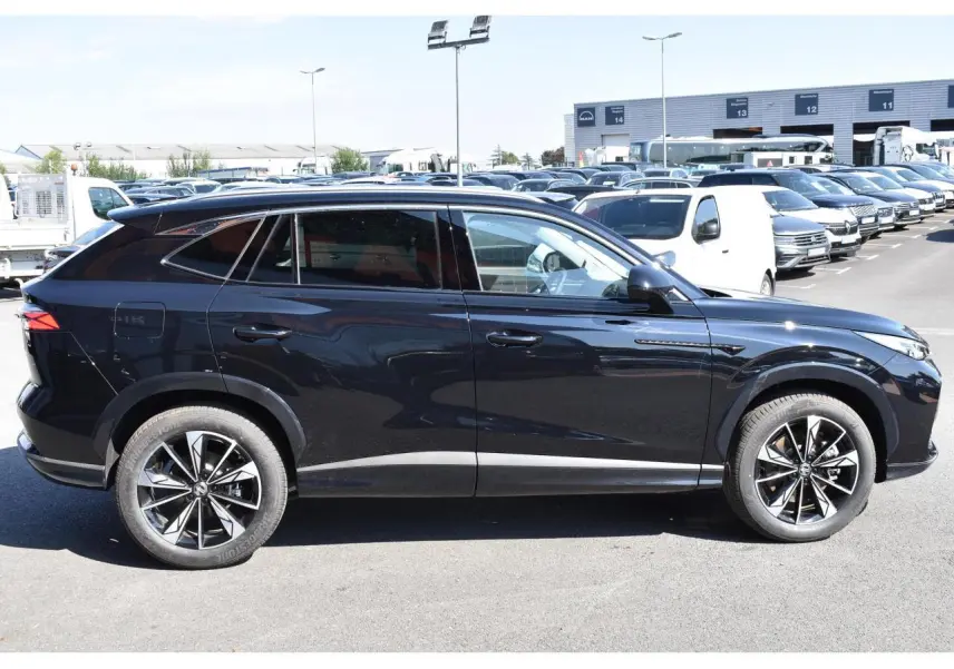 Vue de profil côté gauche du SUV MG EHS noir 2026 avec jantes alliage 19 pouces et vitres surteintées.
