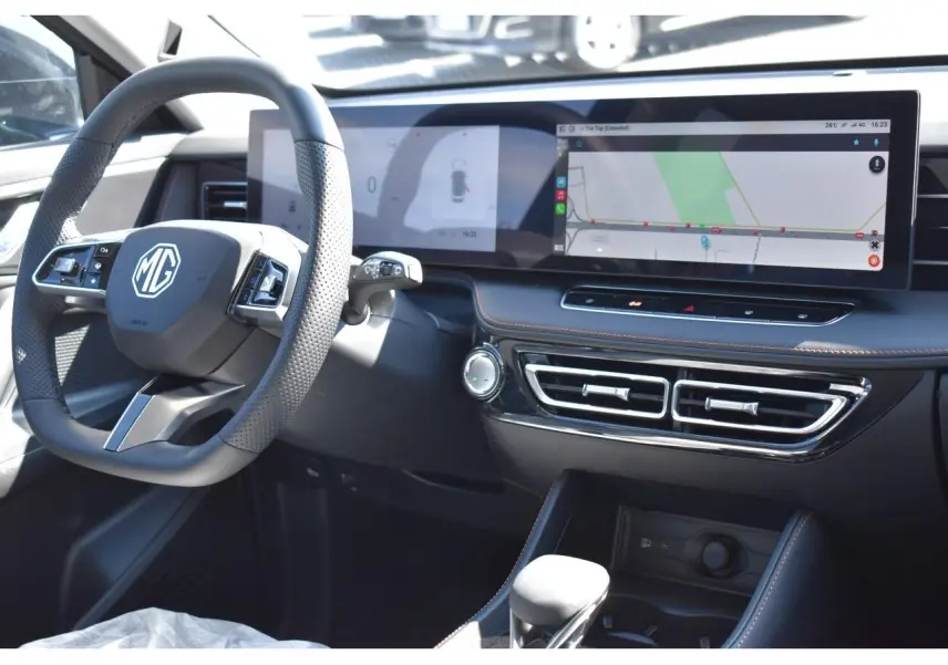 Vue intérieure côté conducteur du tableau de bord noir du MG MOTOR EHS avec écran tactile panoramique et volant multifonction.