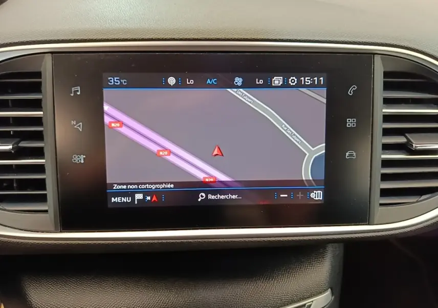 Écran tactile central du tableau de bord de la Peugeot 308 blanc, affichant la navigation GPS en mode carte.