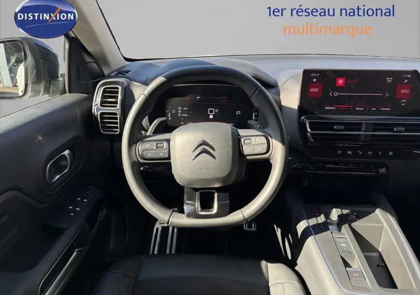 Vue intérieure centrée sur le volant et le tableau de bord du Citroën C5 Aircross blanc nacré 2023, avec écran tactile.