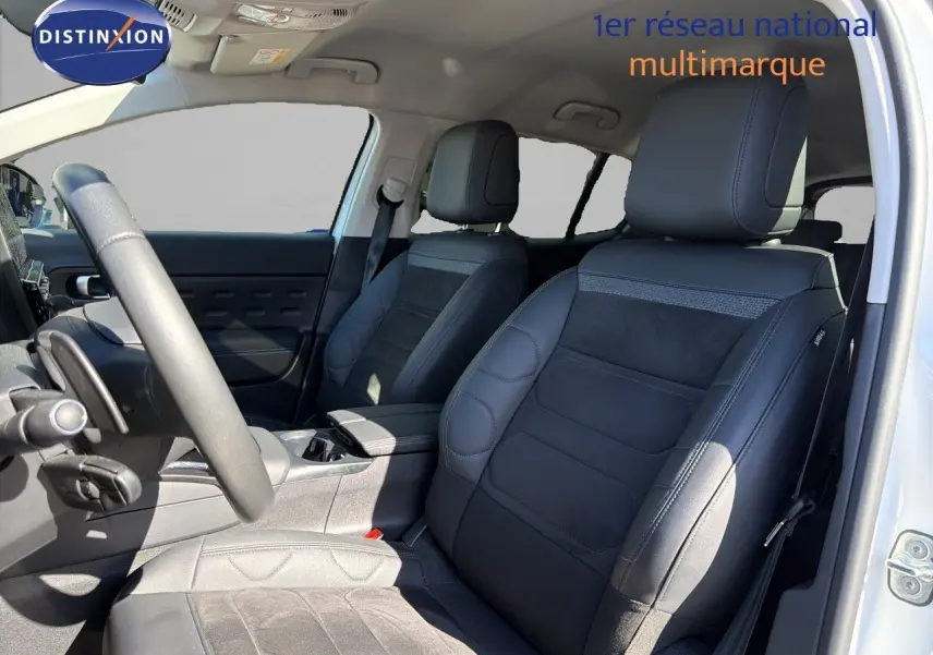 Vue intérieure côté conducteur du Citroën C5 Aircross blanc nacré, mettant en valeur les sièges noirs en cuir et alcantara.