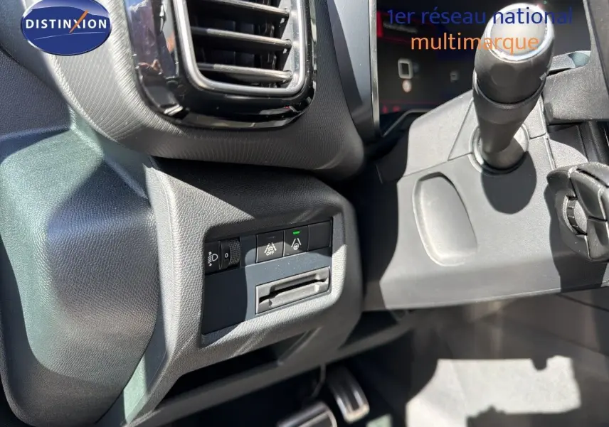 Détail intérieur montrant les commandes d'assistance et la sortie d'aération côté gauche du tableau de bord d'un Citroën C5 Aircross blanc nacré.