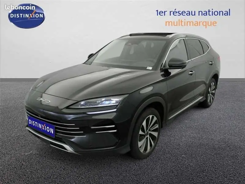 Vue 3/4 avant droite d'un SUV BYD SEAL U hybride rechargeable noir métallisé avec jantes bi-ton et phares LED allumés.