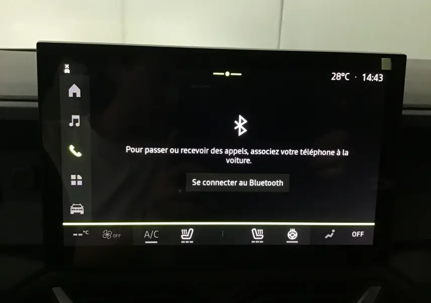 Écran tactile central du Dacia Duster 2025 affichant la connexion Bluetooth et commandes de climatisation et sièges chauffants.