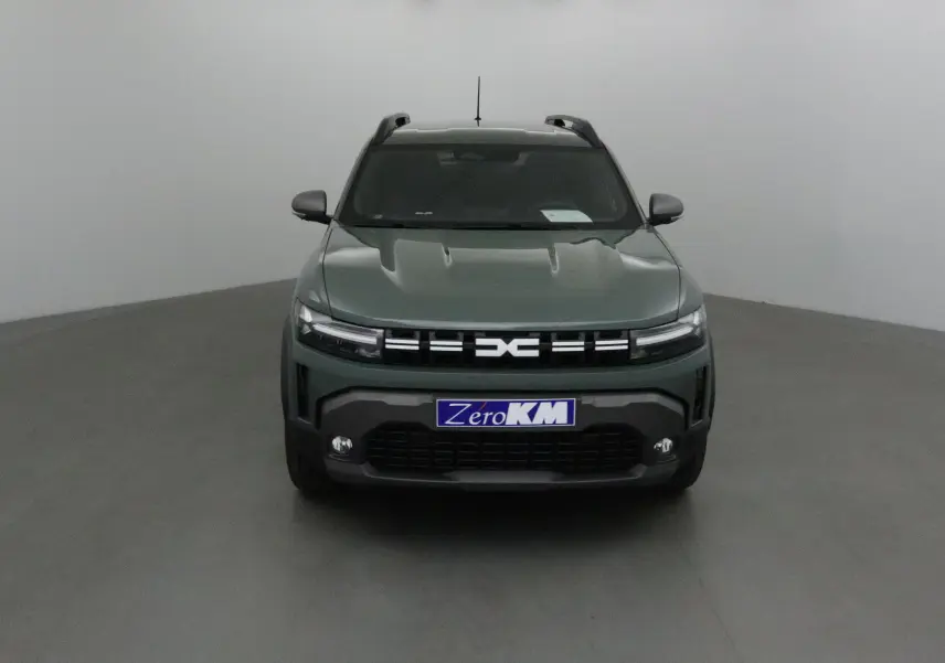 Vue frontale d'un Dacia Duster 2025 kaki lichen avec calandre noire et phares LED fins allumés.