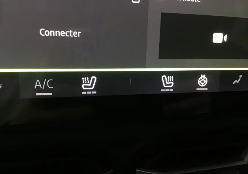 Gros plan sur l'écran tactile du Dacia Duster 2025 montrant les commandes chauffantes des sièges et du volant.