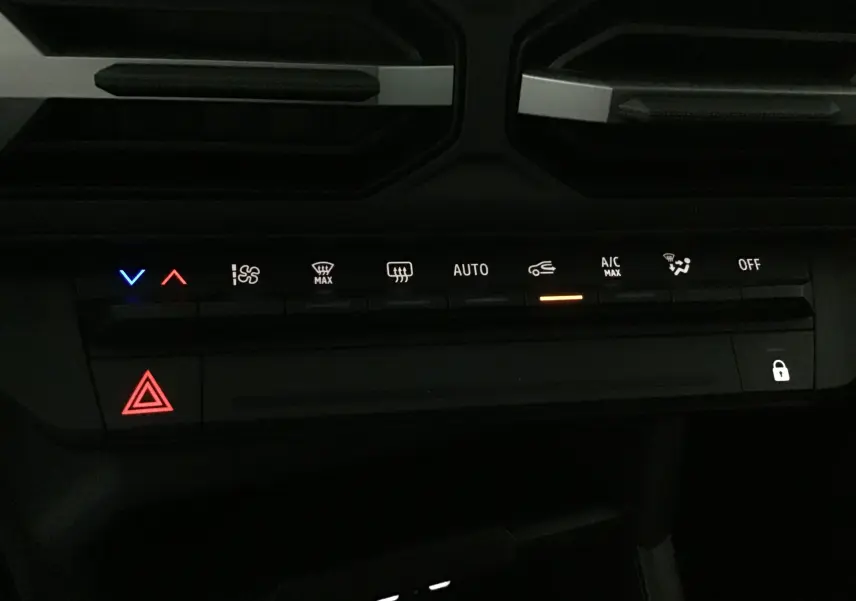 Panneau de commandes climatisation et sécurité du Dacia Duster 2025, avec voyants lumineux rouges, bleus et orange.